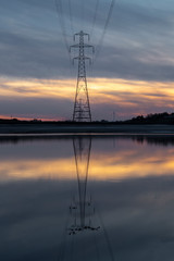 Pylon reflection in after sunset on the Loughor estuary, Llanelli, South Wales, UK