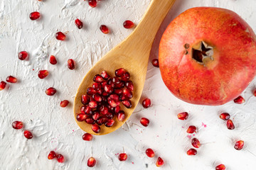a spoon with pomegranate fruit flat lay with seed and grains on the table flat lays