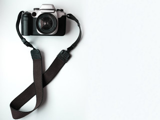 old vintage camera and lens placed on a white table And looks like a digital dslr or film.