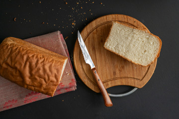 freshly baked sliced white bread with metal knife, toasts for cooking sandwitchs