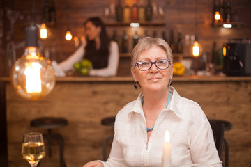 Portrait of elderly woman in a vintage restaurant