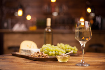 Bowl of delicious golden honey next to a glass of white wine