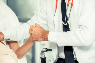 Male doctor is talking and examining female patient in hospital office. Healthcare and medical...