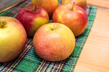 Sweet apples of red color on the kitchen table. Washed vegetables, a guarantee of health. Copy space