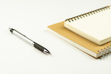 pen and diary book on white desk background.