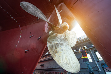 Stevedore, controller, Port Master, surveyor inspect theaft stern propeller of the ship in floating dry dock, recondition of overhaul repairing and painting, sand blasting in dry dock yard - obrazy, fototapety, plakaty