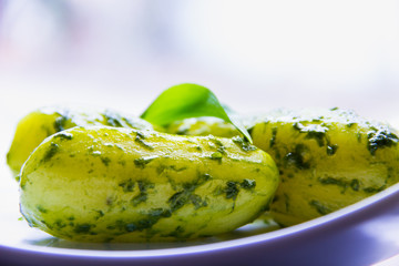 Neue Kartoffeln mit grünem Kräuterpesto  auf einem Teller angerichtet mit einem Bärlauchblatt...