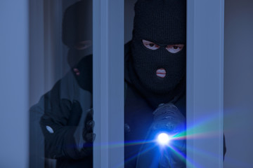 Einbrecher nachts an Fenster vom Haus