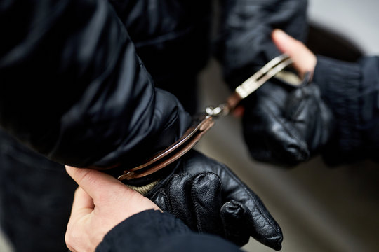 H&auml;nde mit Handschellen hinter R&uuml;cken gefesselt