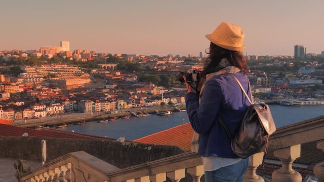 Tourist at the observation deck takes pictures of a view of Porto city, Portugal