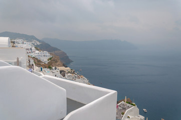 Fototapeta premium Panorama of Oia white houses with caldera immersed in the mist