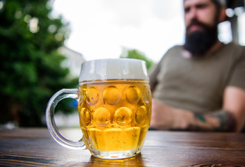 Man sit cafe terrace enjoying beer defocused. Alcohol and bar concept. Creative young brewer. Craft beer is young, urban and fashionable. Distinct beer culture. Mug cold fresh beer on table close up