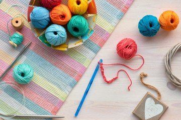 Crochet, top view on yarn balls on light wood