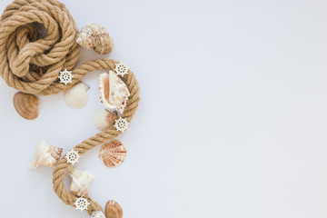 Sea shells with nautical rope on white table