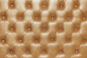 Diamond pattern on the soft headboard close up, with bronze tint of pastel tone. Checkered background Chesterfield style.