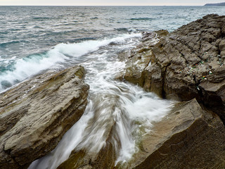 surf on the rocky shore