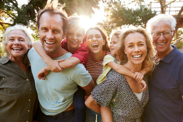 Outdoor Portrait Of Multi-Generation Family Walking In Countryside Against Flaring Sun - Powered by Adobe