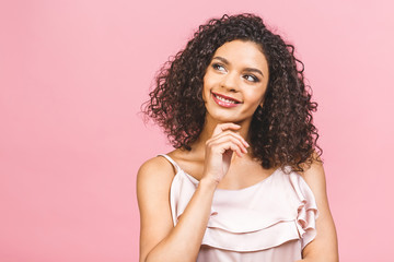 Fototapeta na wymiar Portrait of cheerful young mixed race female with curly hair posing in studio with happy smile. Dark-skinned woman in dress smiling joyfully, showing her white straight teeth