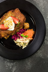 Potato pancake with meat and salad, restaurant dish