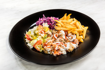 Turkish donner kebab with fries and salad on plate