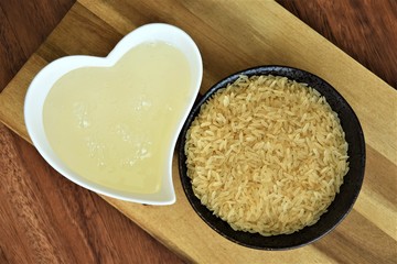 long grain rice and rice syrup in a cup on a wooden natural board