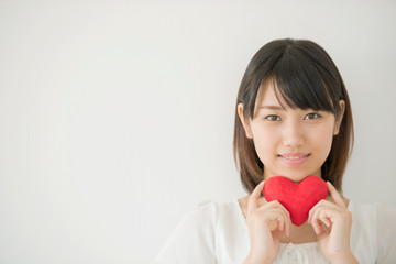 ハートを持ち微笑む女性