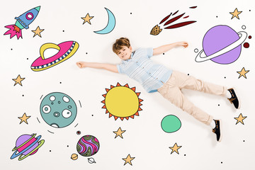 top view of cheerful kid flying in space on white