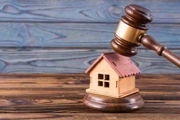 wooden house, judge's gavel on wooden background. purchase, sale of real estate. housing