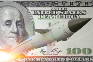 concept rockets sent upwards against a hundred dollar banknote money background. Weapons of mass...
