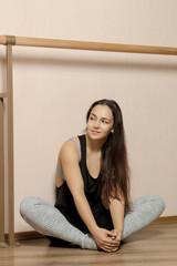 Beautiful girl dancer. tired girl dancer. girl ballerina or dancer is resting near the ballet barre in a dance studio after training.