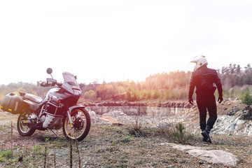 Motorcyclist man stands with his Adventure Motorbike. Off road. Motorcycle trip. enduro Traveling,...