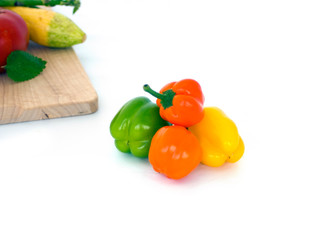 Colored sweet peppers on white with summer veggies