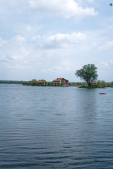 Fototapeta na wymiar Scenic view of the house, lake, bridge in the distance, vertical fish farming