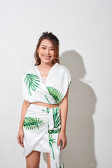 Beautiful young woman in tropical print green and white dress