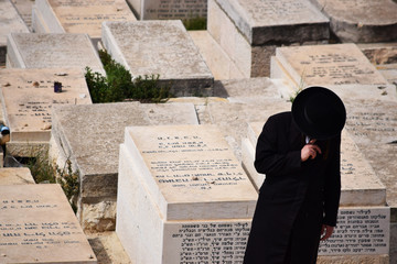 Hombre judío ortodoxo paseando solo por el cementerio de Jerusalén, Israel, Medio oriente.