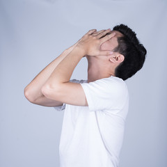 Portrait handsome young asian man wearing a white T-shirt stressed and anxiety isolated on grey background. Asian man people. business success concept.