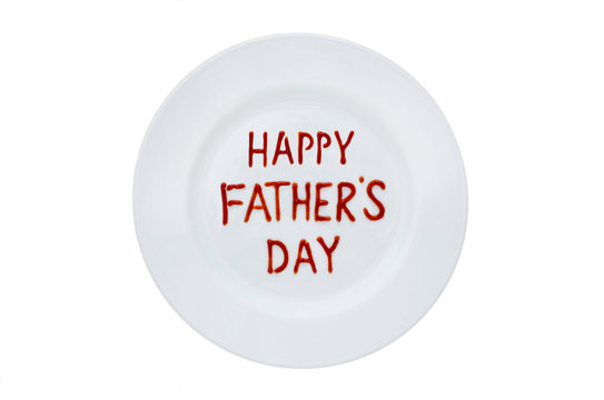 Happy Father's Day written in red ketchup on a white plate. Top view.