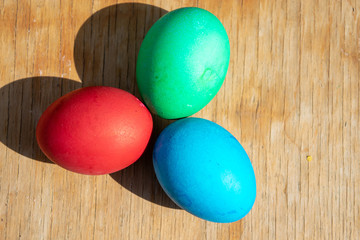 Fototapeta na wymiar Eggs red green and blue on the table Easter