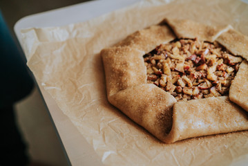 Pie biscuit with apples on parchment paper selective focus