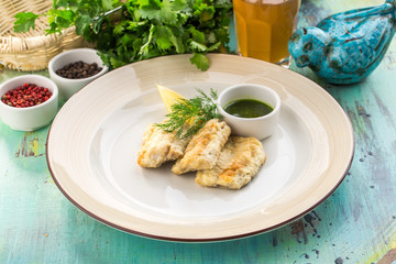 fried fish fillet serve with soy sauce on blue wooden table