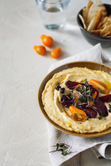 Traditional classic Mediterranean hummus of chickpeas with olive oil served with cherry...