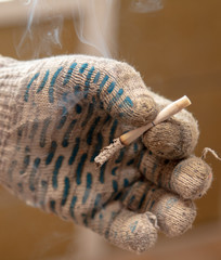 Cigarette in the hand of a worker at a construction site