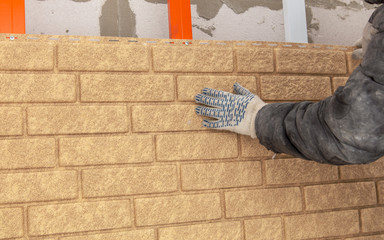 Installing brick siding on the wall of the house