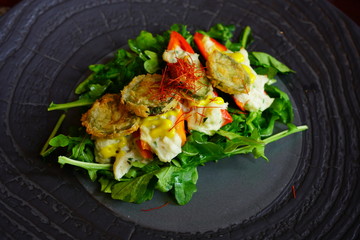 Fried pepper slices on arugula salad