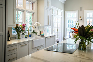 Open Concept Elegant and Spacious Kitchen with Marble Countertops, Chandelier, and Two Toned Cabinets