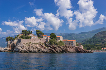 Fototapeta na wymiar View from a boat on a small Island of Sveti Stefan on the Adriatic Sea in Montenegro
