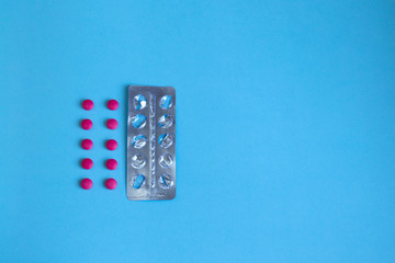 Pills and empty blister on a blue background. Concept pharmacology, medicine. Free space for text