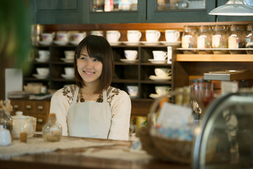 カウンターで微笑むカフェの店員
