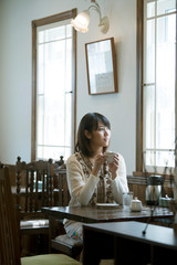 カフェでコーヒーを飲む女性