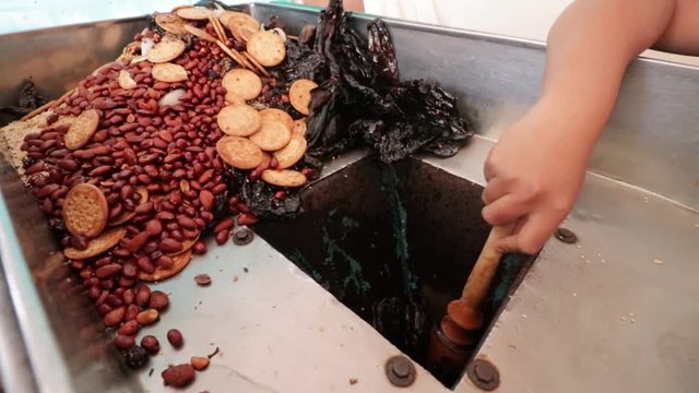 Top Side view. Woman making Mole in Puebla Mexico. North America. Female hands grinding some ingredients. Cooking Traditional recipe.